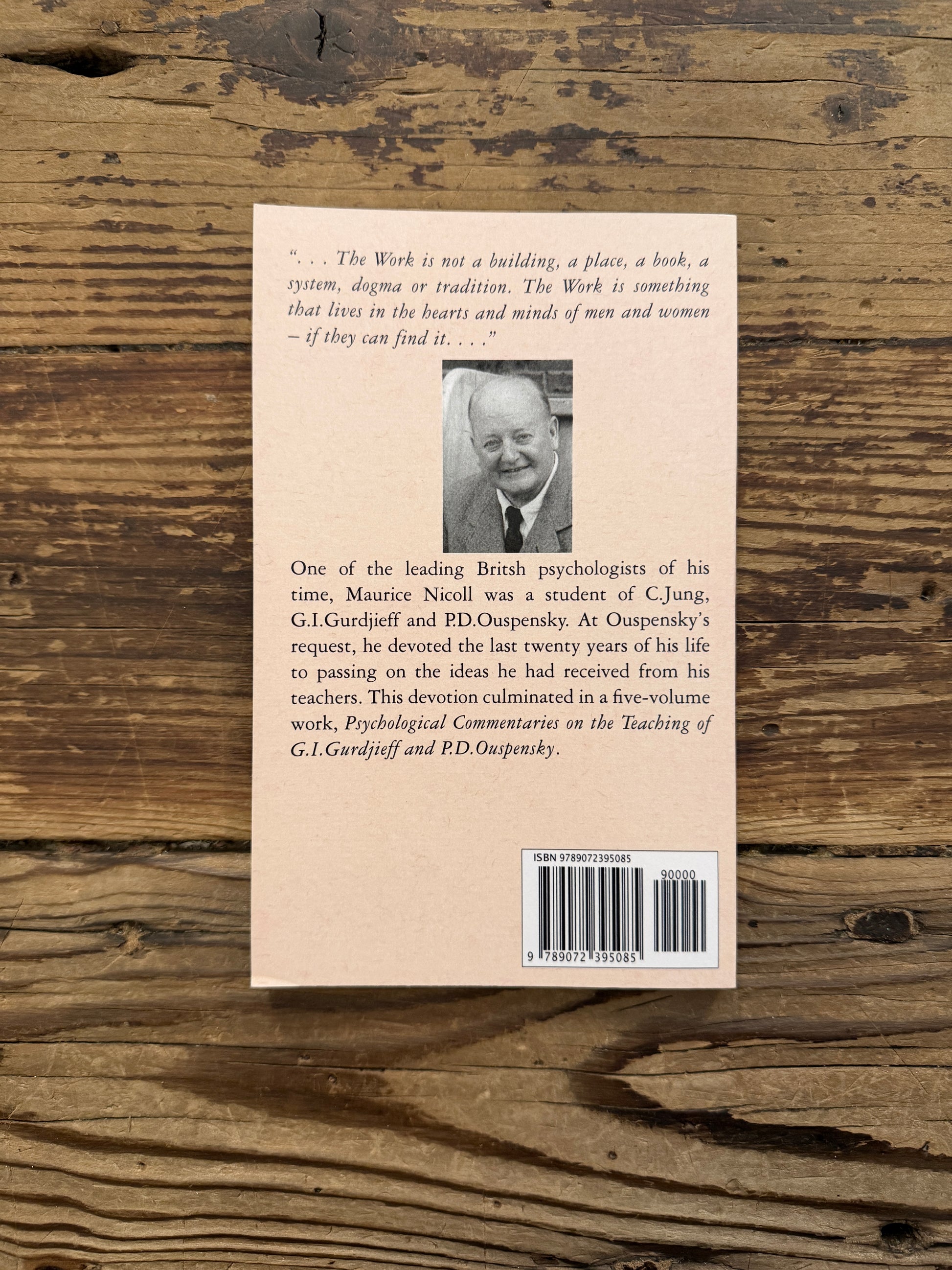Back cover of a book titled 'Notes taken at Meetings' by Maurice Nicoll, published by Eureka Editions on a wooden surface