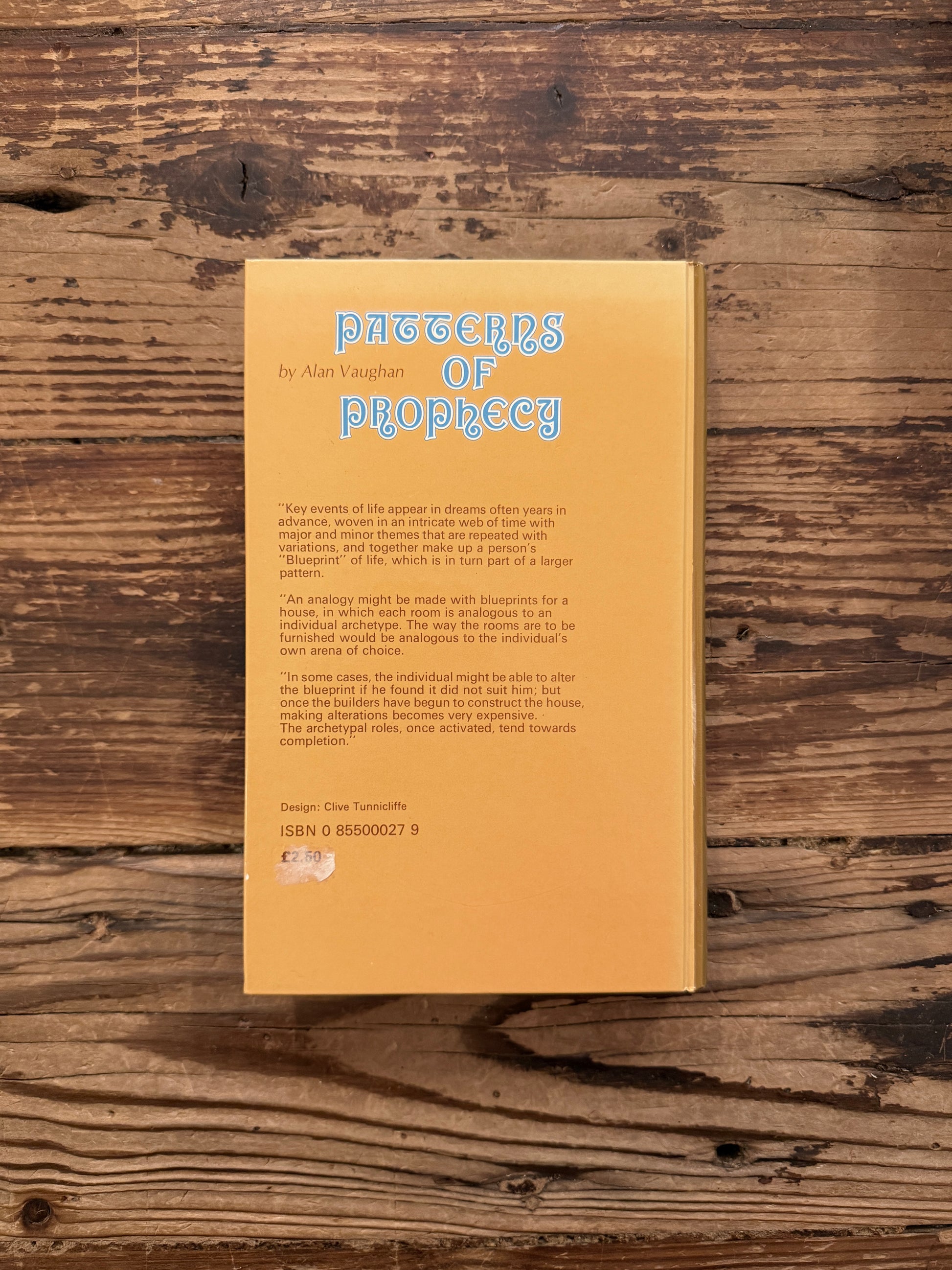 Back cover of a book titled 'Patterns of Prophecy' by Alan Vaughan on a wooden surface