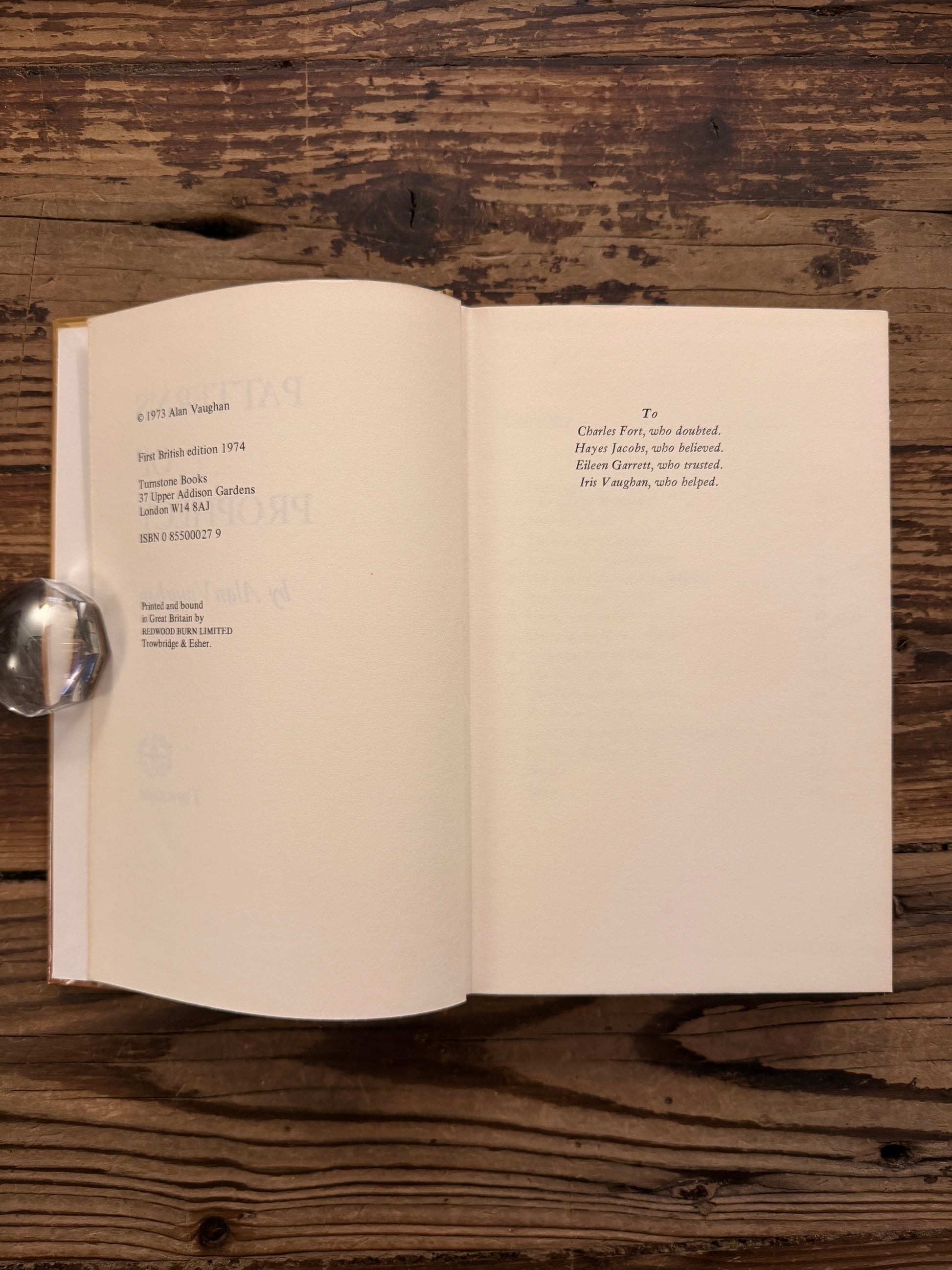 Open book titled 'Patterns of Prophecy' by Alan Vaughan on a wooden surface