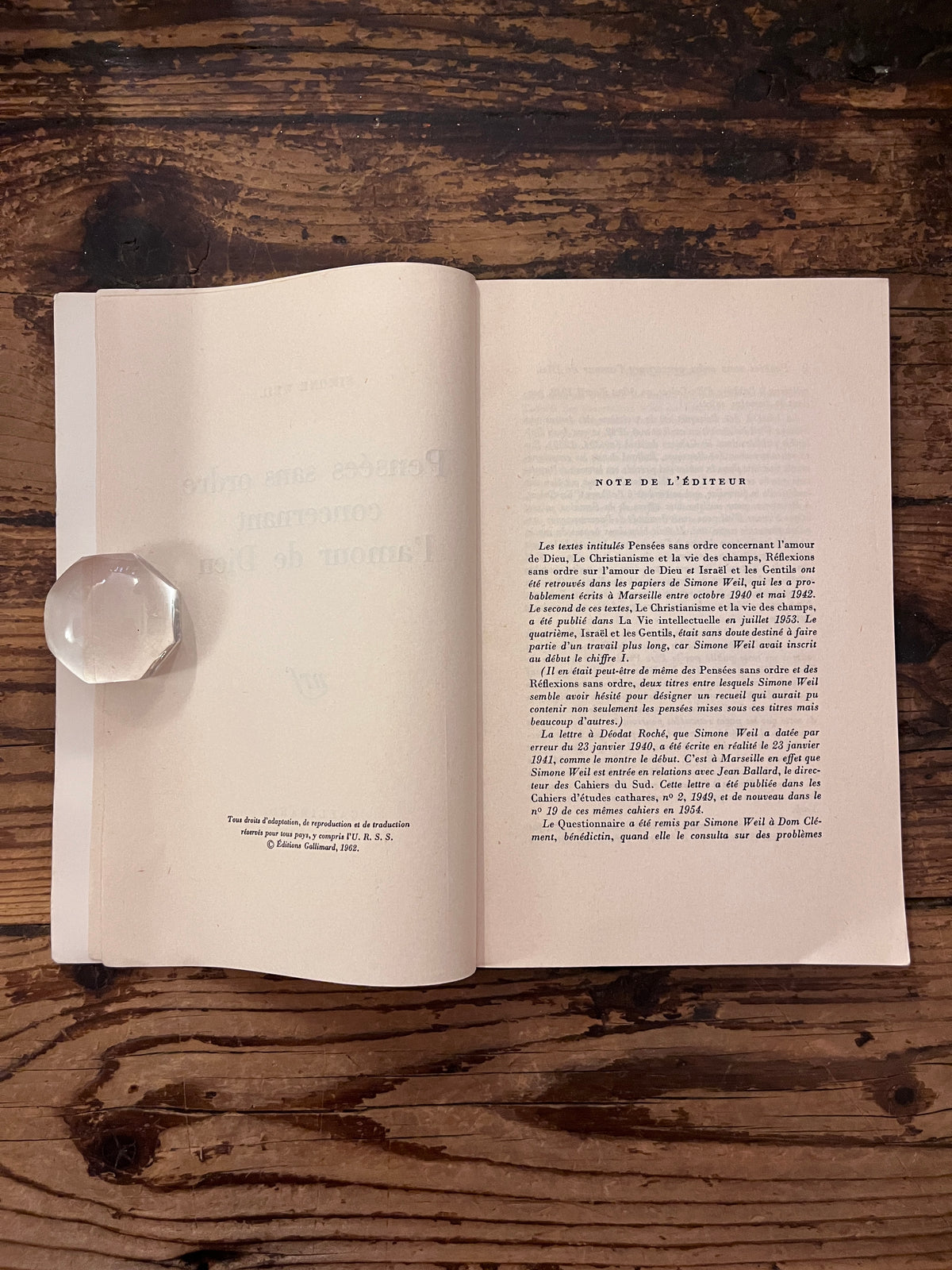 photo de la premiere page de texte du livre "pensees sans ordre concernant l'amour de Dieu"sur fond de bois