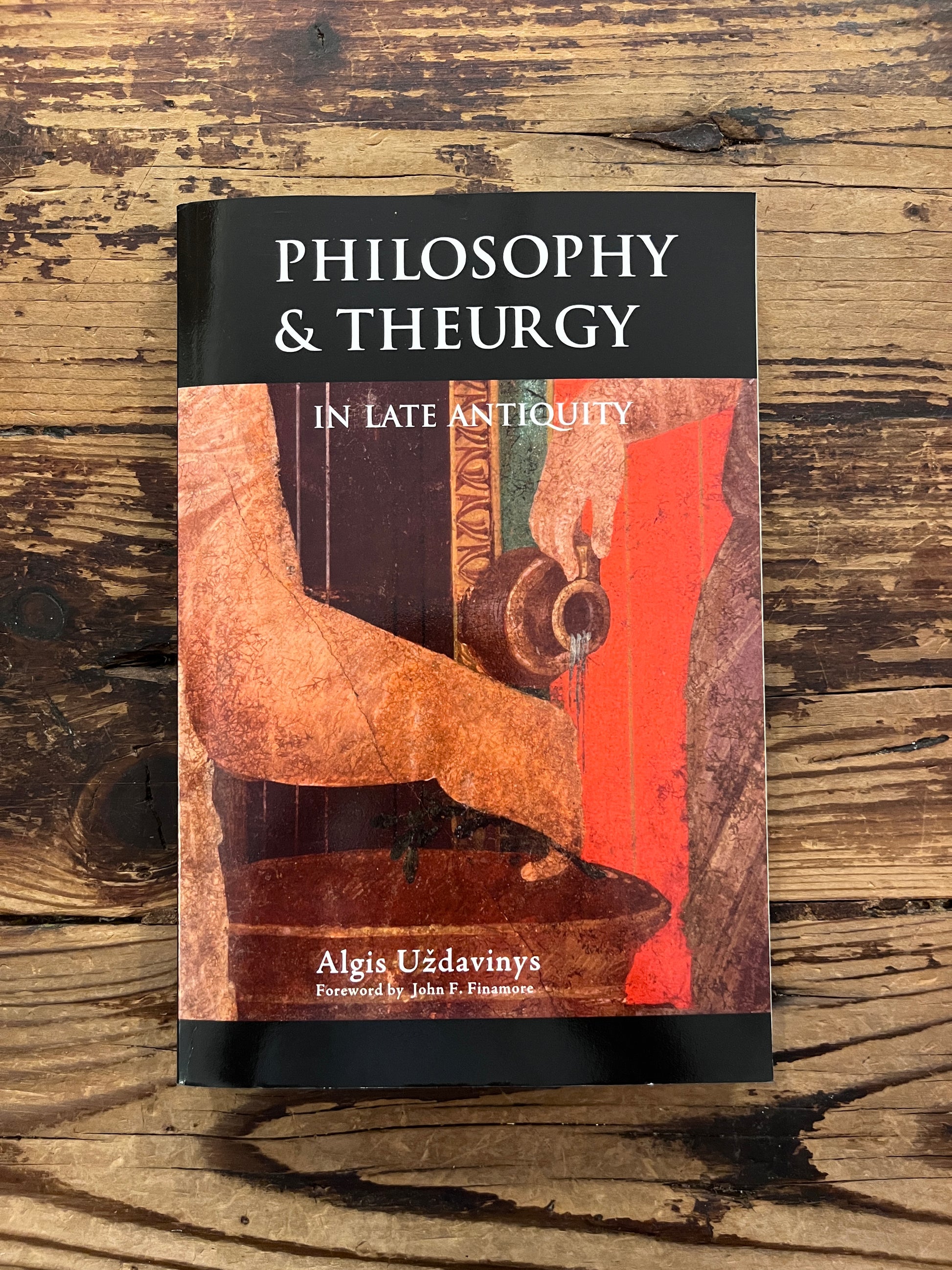 photo of the cover of the book "philosophy and theurgy in late antiquity" on a wooden background