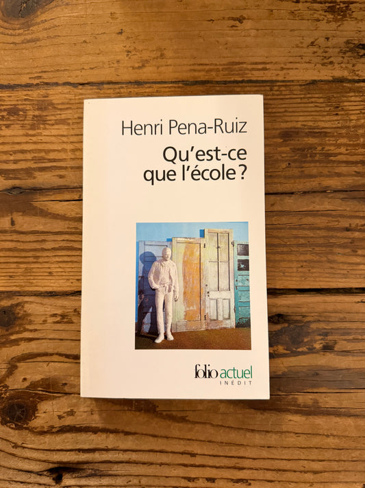 photo de la couverture du livre "que'est ce que l'école ?" sur fond de bois
