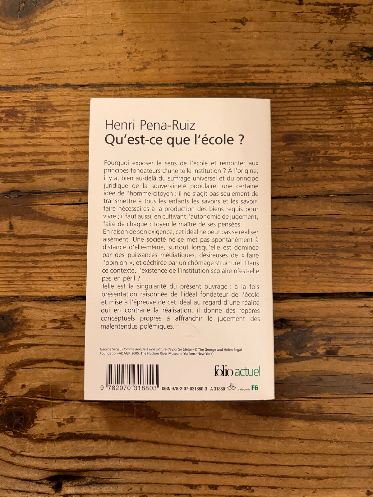 photo de la couverture du livre "que'est ce que l'école ?" sur fond de bois
