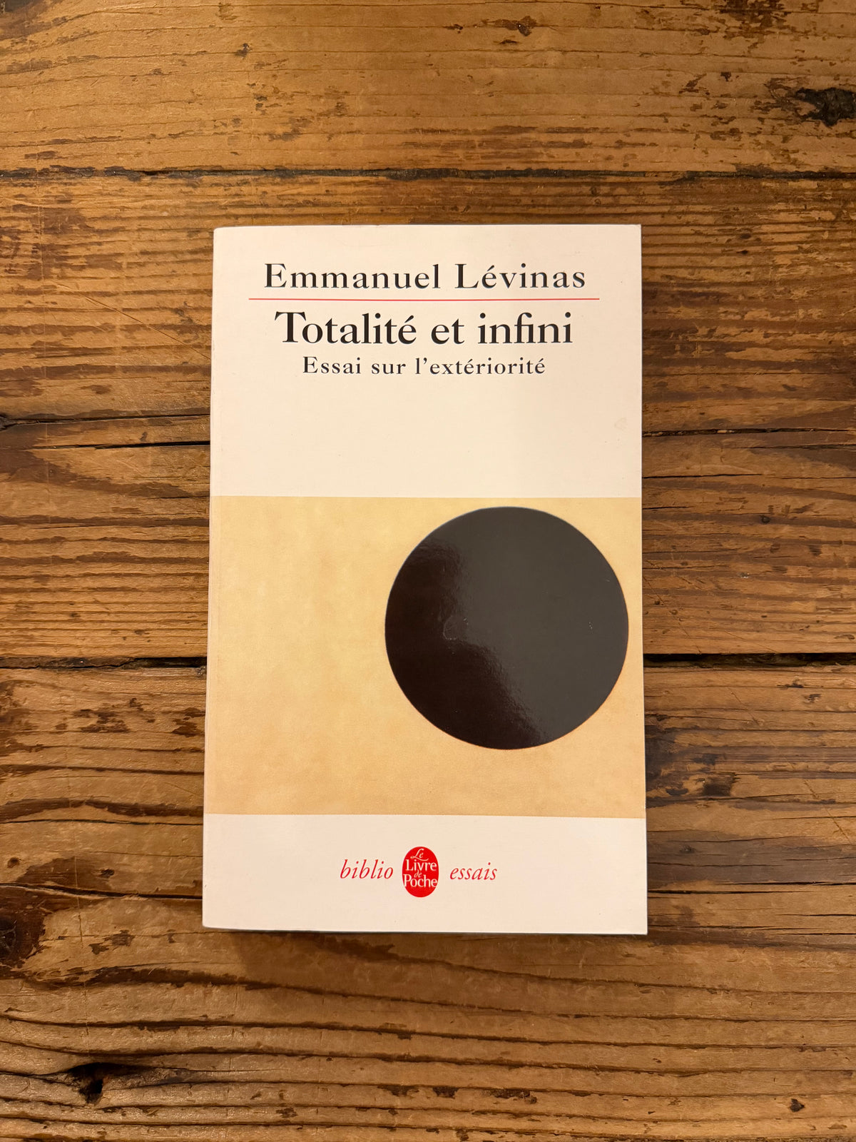 photo de la couverture du livre "totalite et infini" sur fond de bois